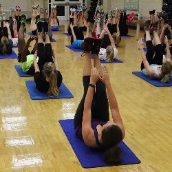 Participants in Ali Herlong's Zumba class complete core strengthening exercises on the floor.