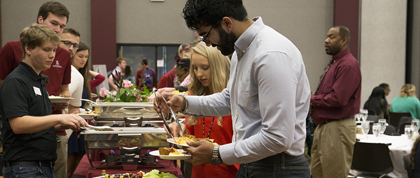 Students fill their plates at the TOAST breakfast awards buffet.