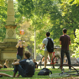 students hanging out on the horseshoe next to the maxcy monument with their bikes and a ball