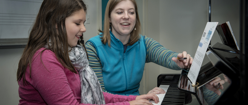 Student teacher and student in piano lesson.