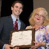 Gregory "Ryan" Toland receives the Outstanding Electronic Journalism Award for Leadership from Cecile Holmes, sequence head.