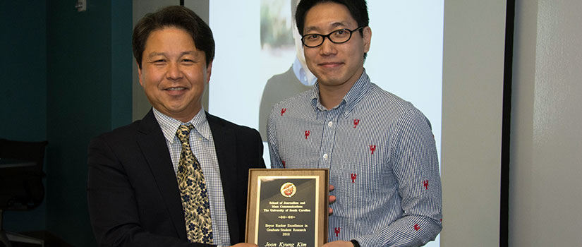 Dr. Sei-Hill Kim presents Joon Kim the Bryce Rucker Research award.