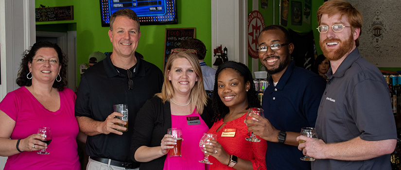 Young Alumni Board Members stand with Dr. Gazke at Craft and Draft
