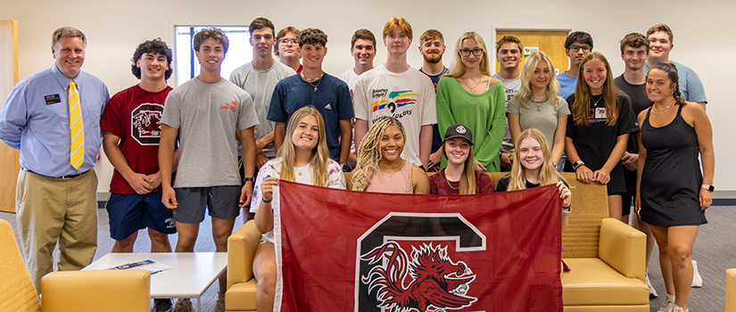 A group of students gather for a photo on the sixth floor of the Close-Hipp Building on the first day of classes in fall 2023.