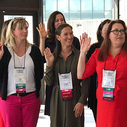 Christina Saragnese raises her right hand with a group of inductees at the Society of Government Meeting Professionals National Chapter Board meeting.
