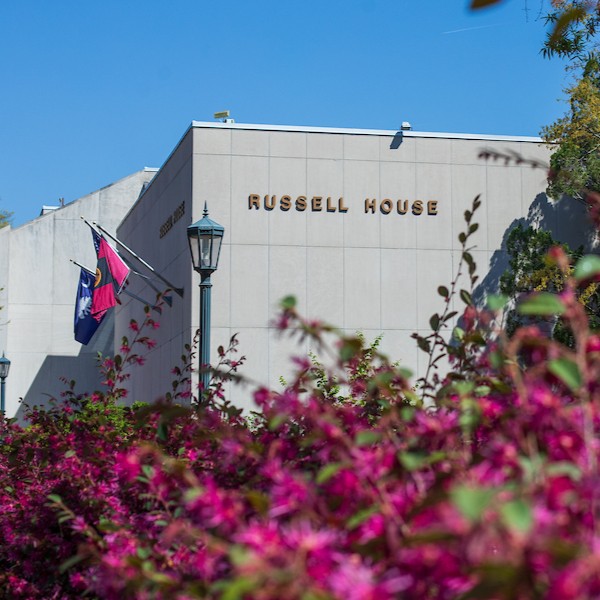 view of Russell House with pink flowers blooming in the foreground