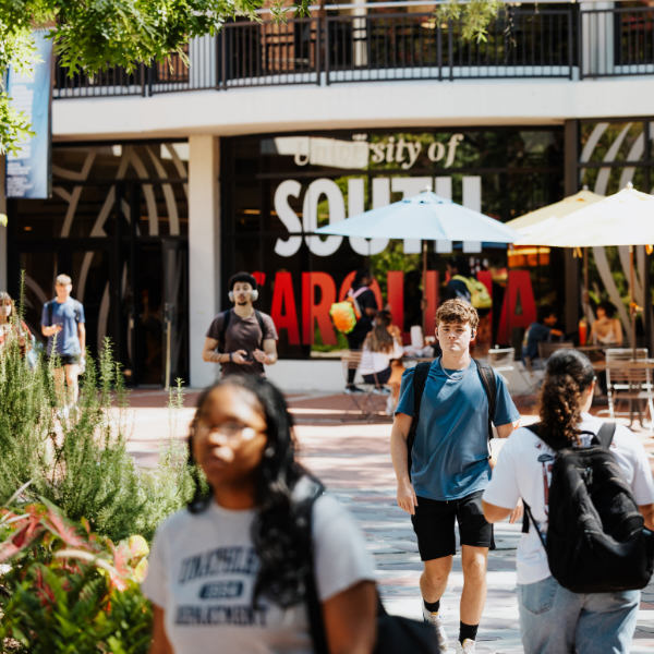 students walking past a university of south carolina sign