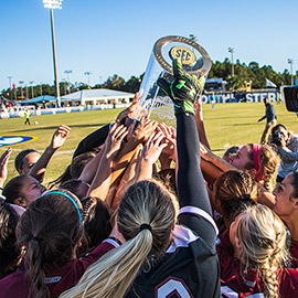 women's soccer celebrating with the SEC championship trophy
