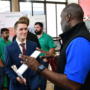 Male USC student speaks to business representative at the STEM Job Fair.