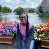 Jhy-Ann Walk sits with flowers on a bridge in Amsterdam