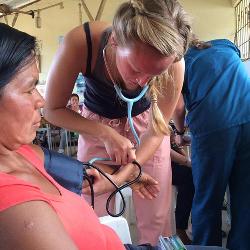 Sophomore Alaina Sturkie takes a woman's blood pressure during UofSC Timmy Global Health chapter's August trip.