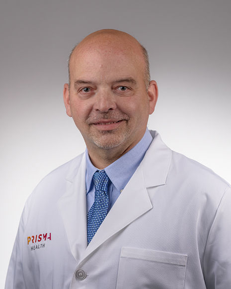 Photo of Dr. Mark Friedman in a white lab coat in a studio.