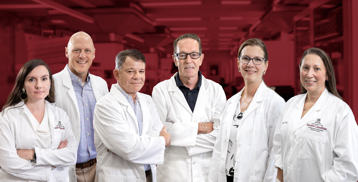 Group photo of the institute's primary researchers and core directors against a garnet-hued backdrop of a cardiovascular disease research lab.