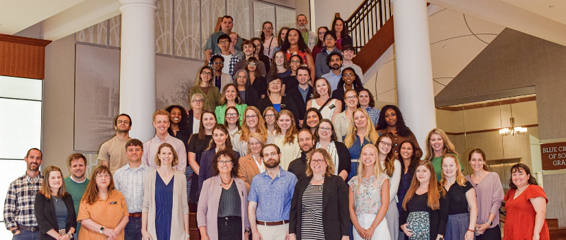 Large group of researchers and students gathered on a staircase for a program photo.