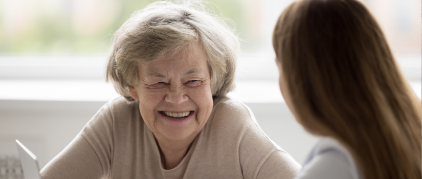 older woman talking with a worker with a laptop