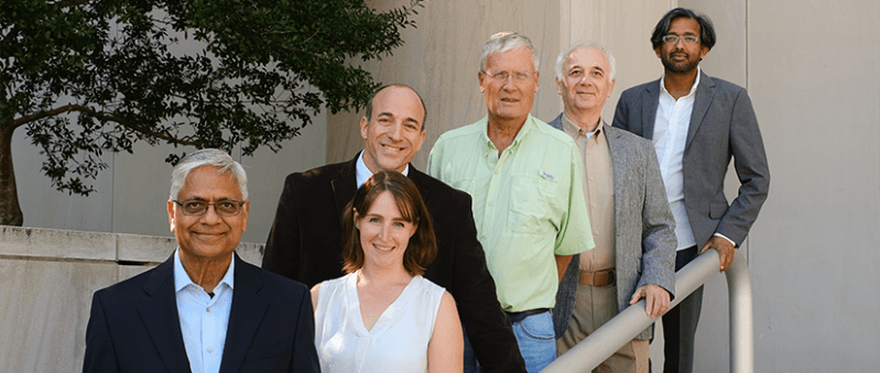 Six of the key researchers standing on steps together smiling