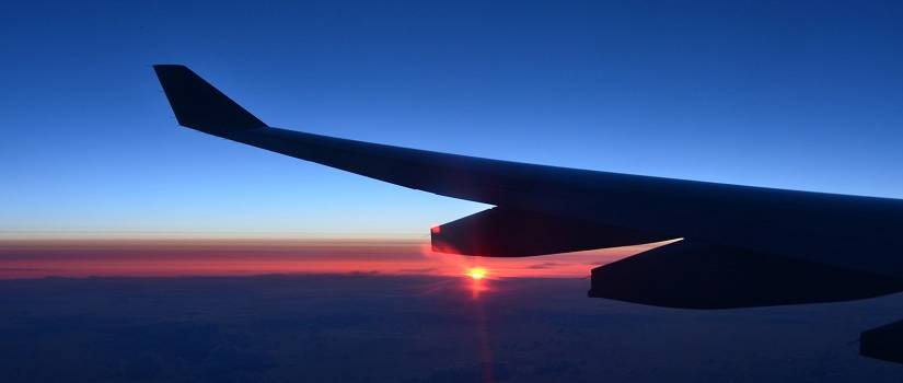 Airplane wing with sunset in the background