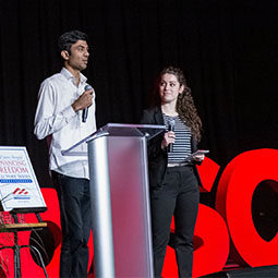 A male and female student speak onstage during the annual showcase event