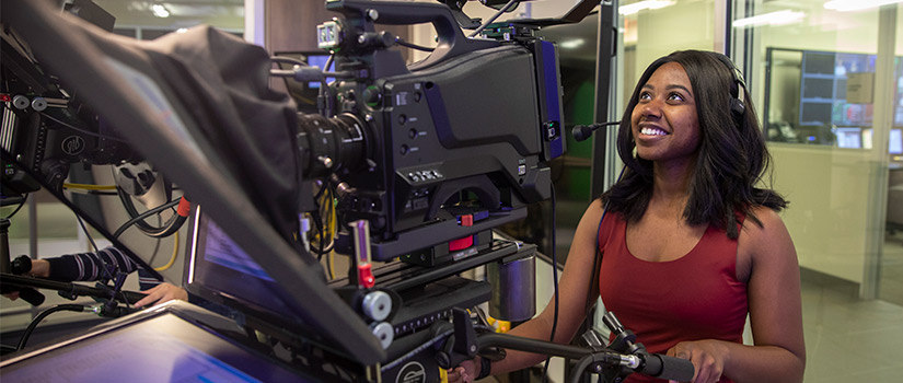 a female student operates a television studio camera