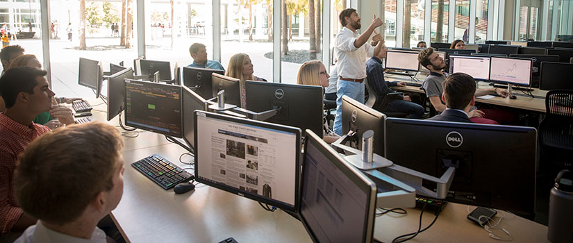 A professor teaches students in a computer lab