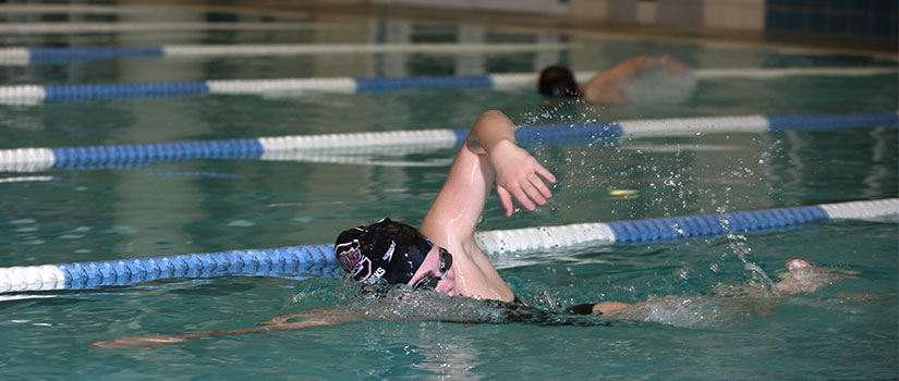 female student swimming laps in pool