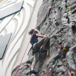 student climbing rock wall