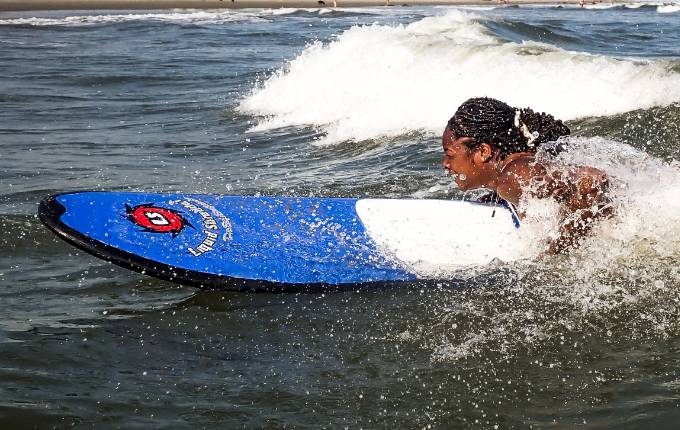 Student surfing on an outdoor recreation trip.