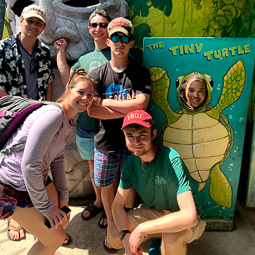 students posing at a sea turtle exhibit