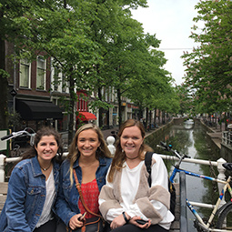 three students posing by a canal in Amsterdam