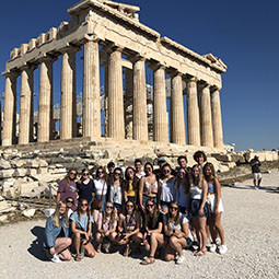 Students sitting in front of ancient ruins