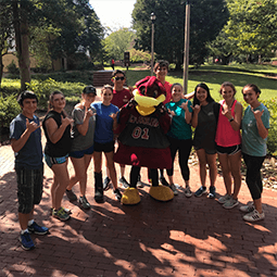UofSC mascot, Cocky, standing with a row of students outside