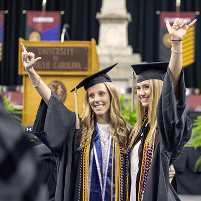 Two students posing at graduation.