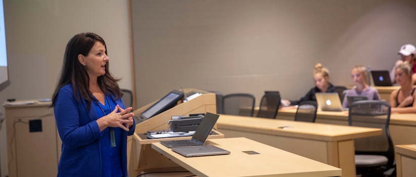 Leslie Hendrix teaching in front of a large class