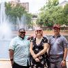 Three students with disabilities smile before the library fountain.
