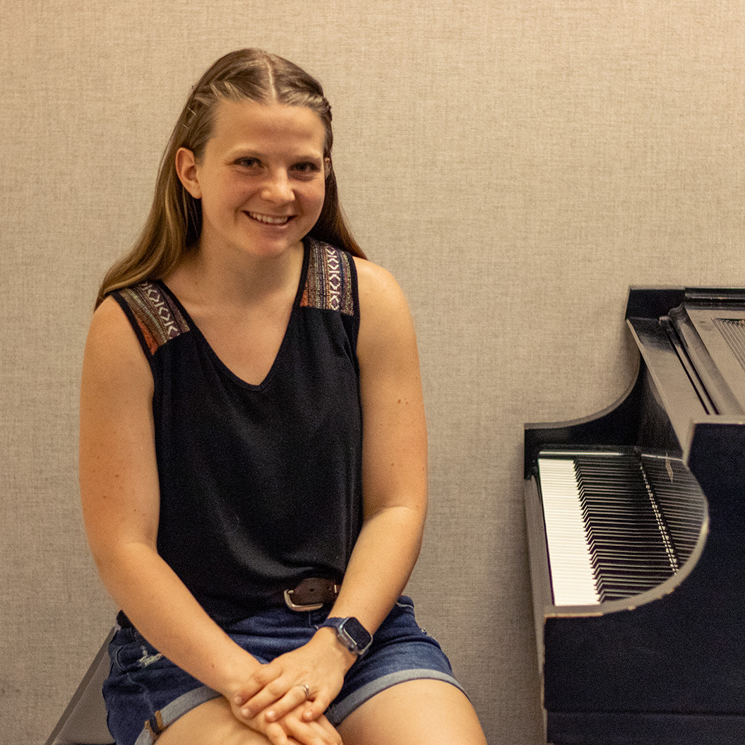 Close-up of a student sitting next to her practice piano.