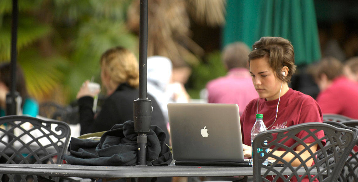 Student sitting at table using a laptop