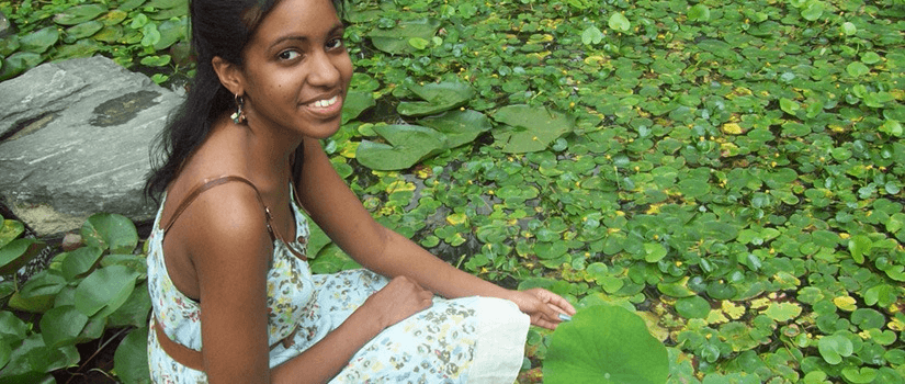 girl sitting near a pond in Southeast Asia
