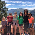 group of students standing in front of a mountain