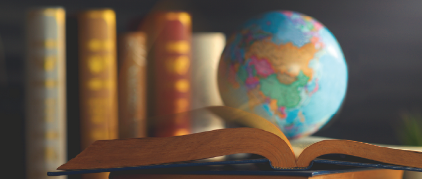 Globe on top of a book on a desk