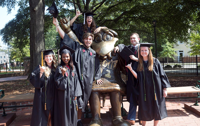 UofSC Graduates posing with the Cocky statue.