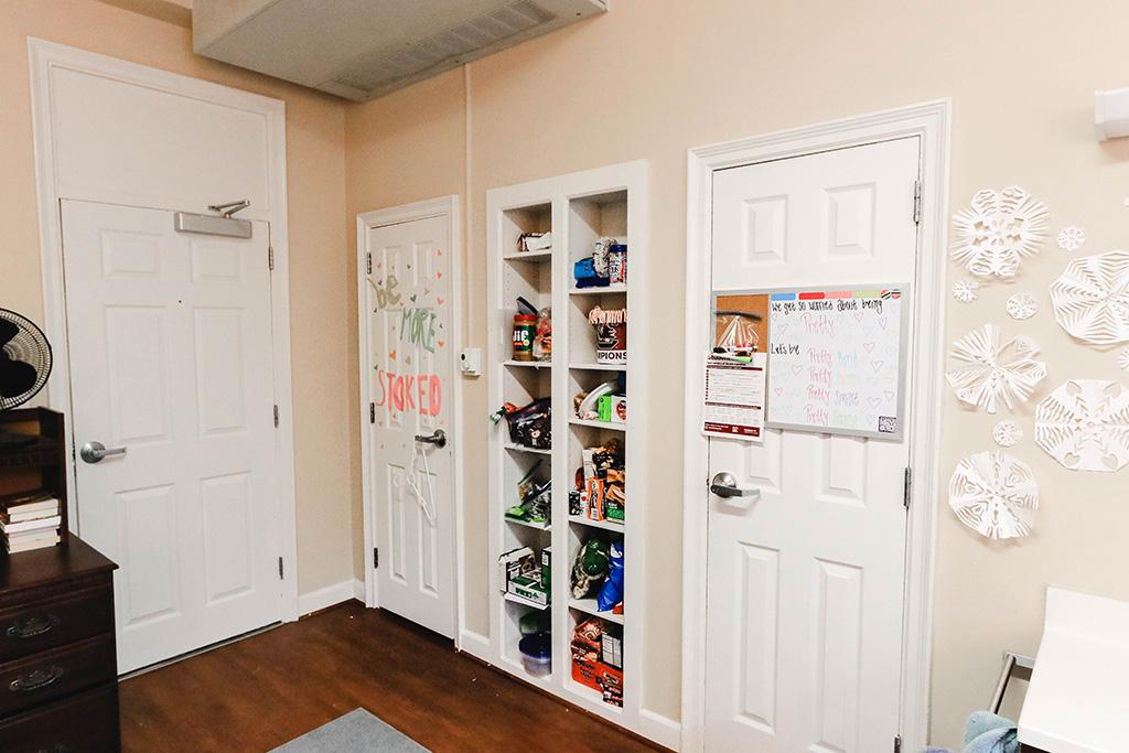 Standard room with two twin beds, two four drawer dressers with mirror on top, two desks with chairs, individual closets and a sink with a mirror.