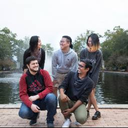 group of students laughing by library fountain