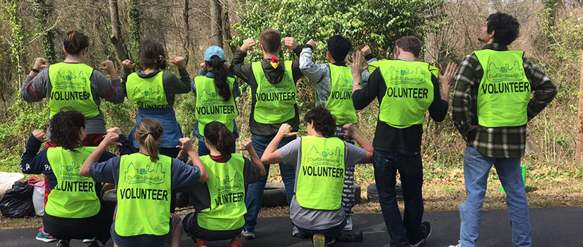 Volunteers show-off their reflective vests during a clean-up day.