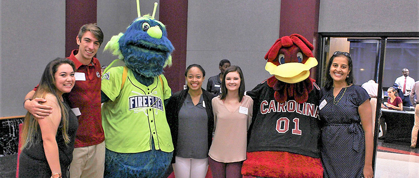 Students pose with Cocky and the Columbia Fireflies mascot.
