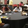 A group of students and mentors chill the Brother 2 Brother Community Dinner.
