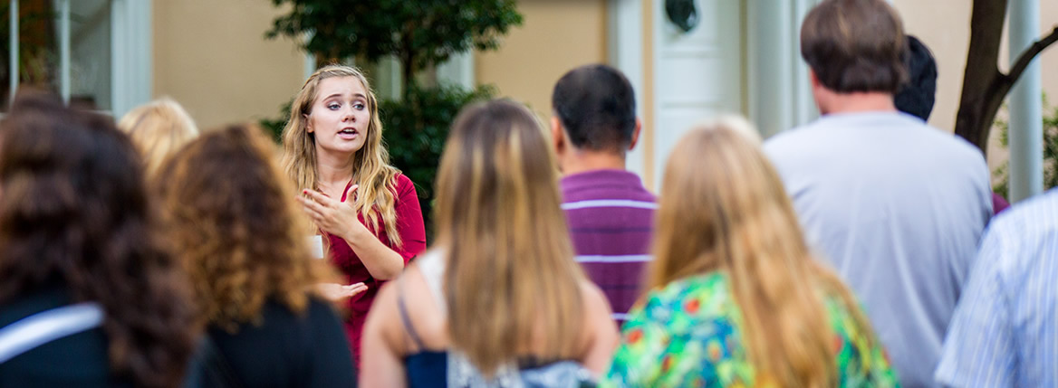 A student speaks before a campus tour group.