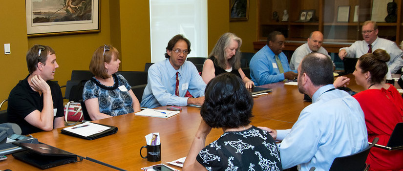 Faculty and staff members gather at a round table for a discussion