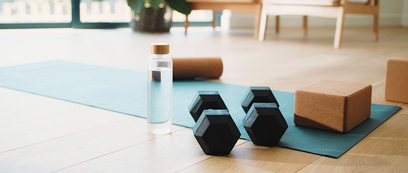Exercise equipment and water bottle arranged on a yoga mat