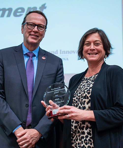 Jessica Stucker and Julius Fridriksson pose while Stucker displays her Excellence in Research Administration award.