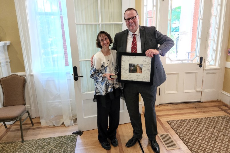 UofSC Vice President for Research Julius Fridriksson (right) presented Julie Morris (left) with an appreciation award and a matted Horseshoe photo signed by friends and colleagues at her retirement reception, held at the historic Spigner House on the UofSC campus.